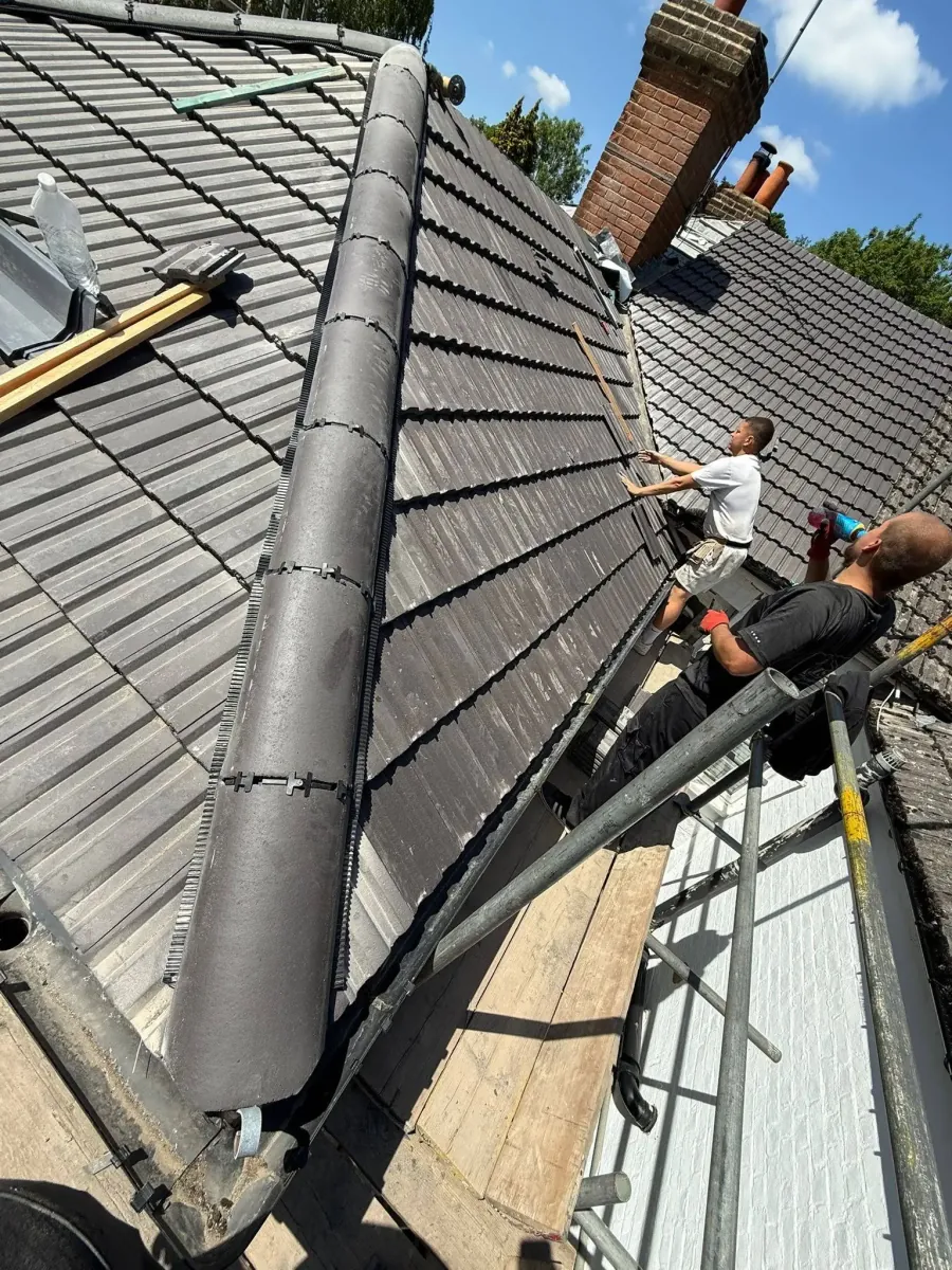 Roofer repairing a leaking roof on a property in Bagshot