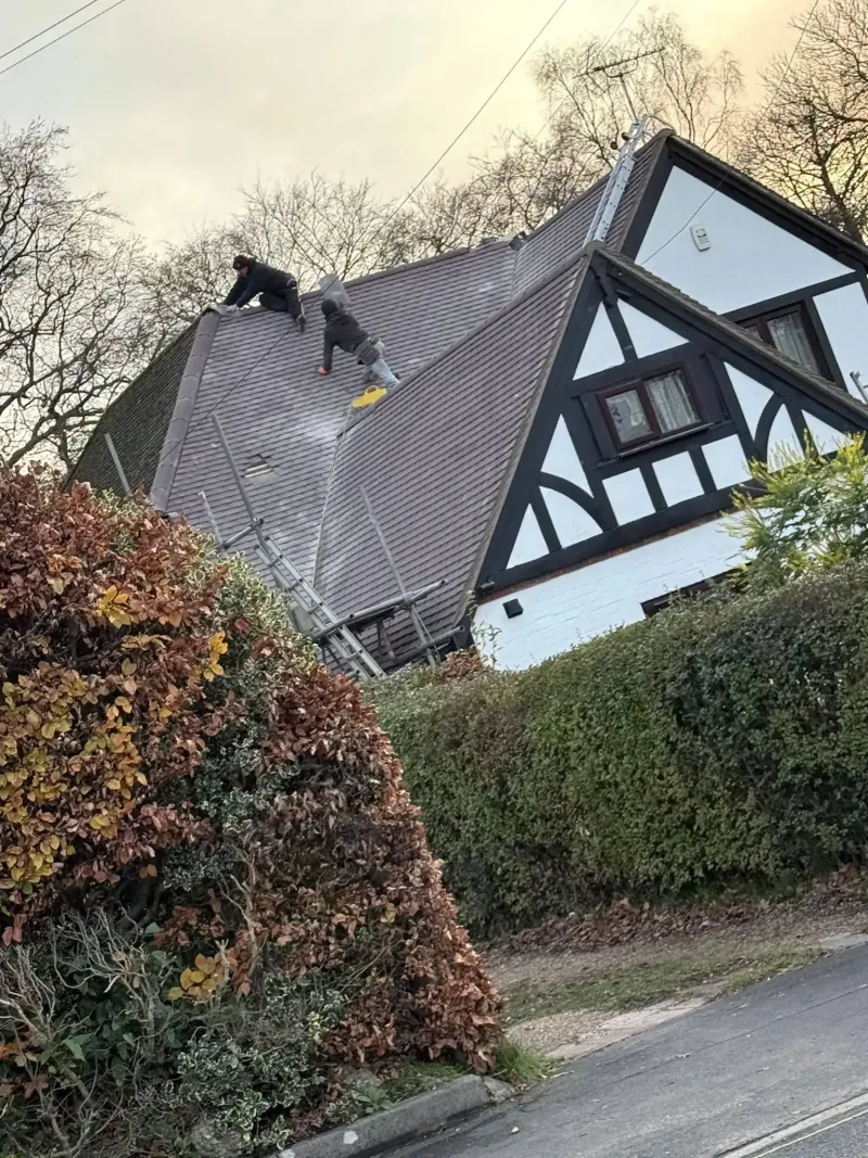 Roofer carrying out repairs to a tiled roof in Bagshot, Surrey